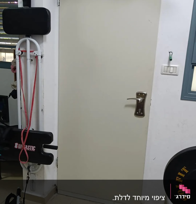 דלת לבנה עם ידית מתכת בחדר כושר ביתי